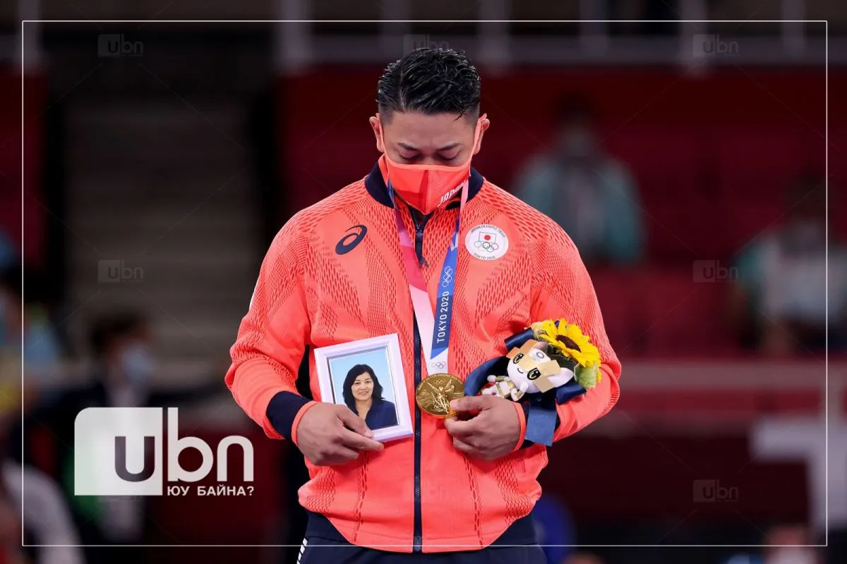 legacy:Olimpic games/ontsloh photo/Japan's Ryo Kiyuna holds a photo of his late mother after winning gold in karate's kata event on August 6. Kiyuna is from the island of Okinawa, which is considered the birthplace of karate. copy.jpg